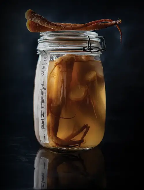 A glass jar filled with a fermented liquid containing Kombucha with SCOBY inside and resting on top of the jar. This image represents one of the best Indian foods for gut health due to its natural probiotics.